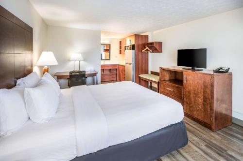 a hotel room with a large bed and a flat screen tv at Suburban Studios Middlesboro in Middlesboro