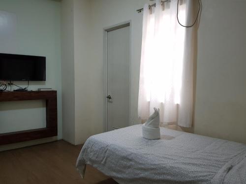 a room with a bed and a tv and a window at Hotel Giorgio in General Santos