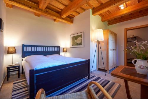 Un dormitorio con una cama azul y una mesa en Lubka Lodge, en Lučatín