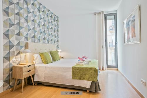 a small bedroom with a bed and a table and a window at Alcam Glorias in Barcelona