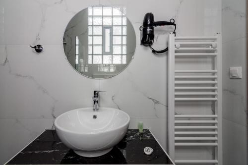 a bathroom with a white sink and a mirror at 105 Adrianou Plaka in Athens