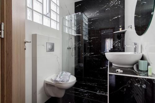 a black and white bathroom with a toilet and a sink at 105 Adrianou Plaka in Athens