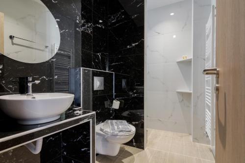 a black and white bathroom with a sink and a toilet at 105 Adrianou Plaka in Athens