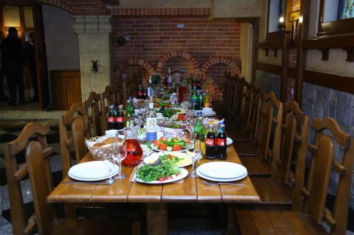 a wooden table with food and drinks on it at Ureni Hotel in Kʼasakh