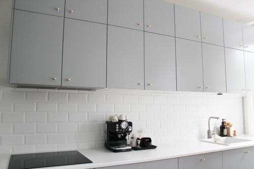 una cucina con armadietti bianchi e una macchinetta del caffè su un bancone di Apartment Rose a Spirkelbach