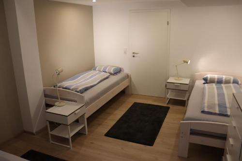 a small bedroom with two beds and two tables at Apartment "Anne" in ehemaliger Schuhfabrik in Herxheim