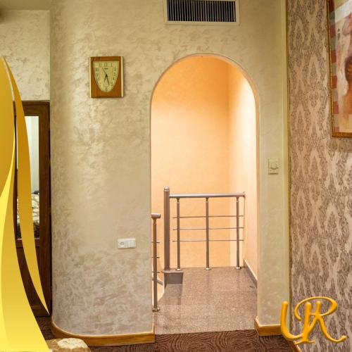 a hallway with an archway and a clock on the wall at Ureni Hotel in Kʼasakh