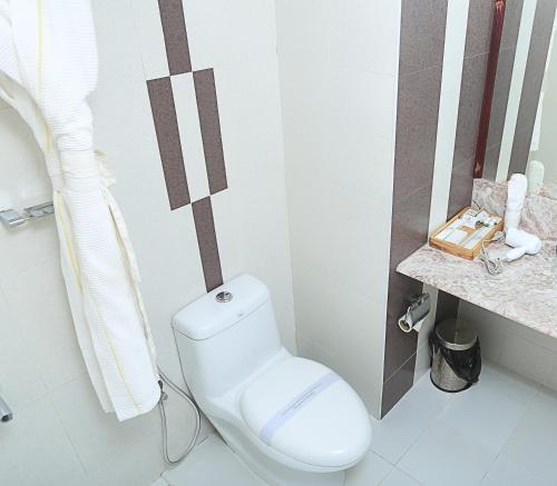 a bathroom with a white toilet in a room at AQUARIA THE BOUTIQUE RESORT in Cochin