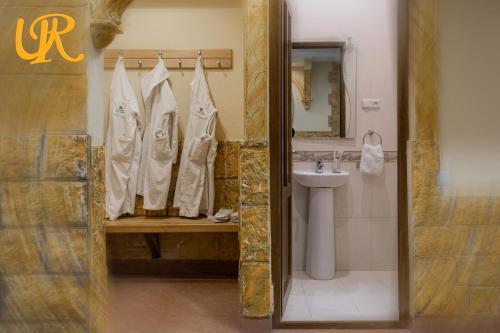 y baño con lavabo, aseo y espejo. en Ureni Hotel, en Kʼasakh