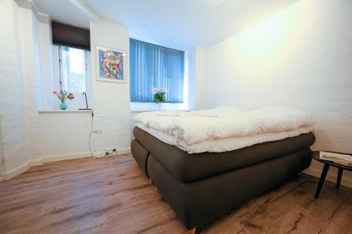a bedroom with a bed and a window at Lake - Pleasant 2-Bdr Apt in City Center in Copenhagen