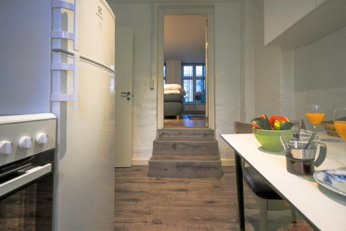 a kitchen with a refrigerator and a table in a room at Lake - Pleasant 2-Bdr Apt in City Center in Copenhagen