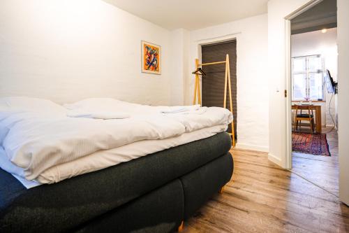 a bedroom with a bed with white sheets on it at Lake - Pleasant 2-Bdr Apt in City Center in Copenhagen