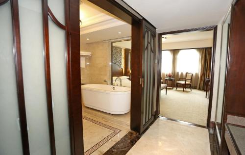 a bathroom with a bath tub and a sink at Grand Palace Hotel - Grand Hotel Management Group in Guangzhou