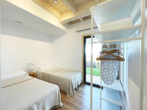 a bedroom with two beds and a ladder and a window at Apartamentos Biopasivos Living Pura Madera in Chiclana de la Frontera
