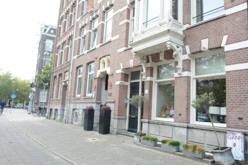 a brick building on a city street next to a sidewalk at NL Hotel District Leidseplein in Amsterdam