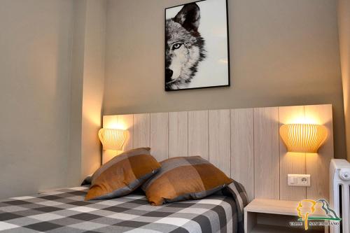 a bedroom with a wolf picture on the wall at Hotel Rural Valle San Emiliano in San Emiliano