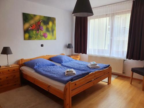 ein Schlafzimmer mit einem Bett mit blauer Bettwäsche und Handtüchern darauf in der Unterkunft Grüner Baum in Neckargerach