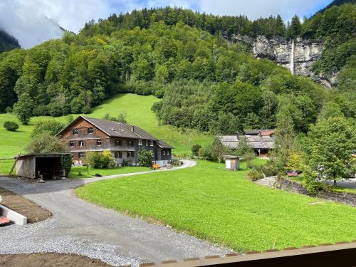 a house in the middle of a field with a mountain at SMART Apartments Mellau in Mellau