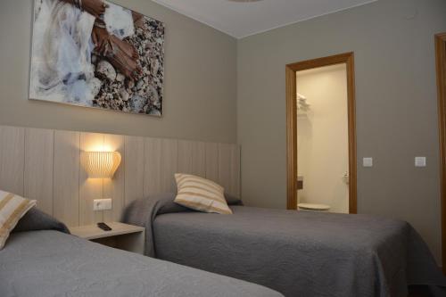 a hotel room with two beds and a mirror at Hotel Rural Valle San Emiliano in San Emiliano