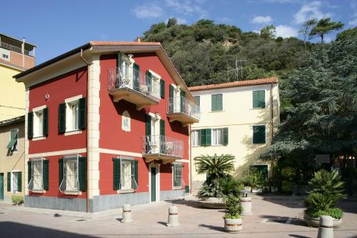 a red building with balconies on a street at Appartamenti In Piazzetta in Deiva Marina