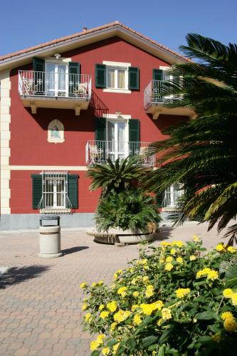 a red building with flowers in front of it at Appartamenti In Piazzetta in Deiva Marina