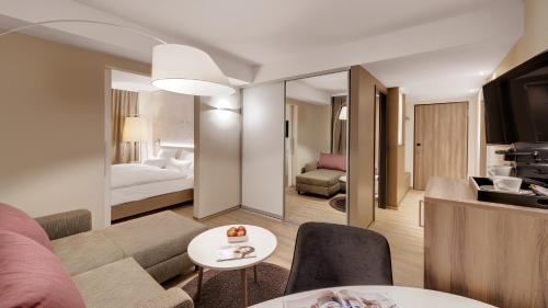 a living room with a couch and a bedroom at Hotel Stadt Lörrach in Lörrach