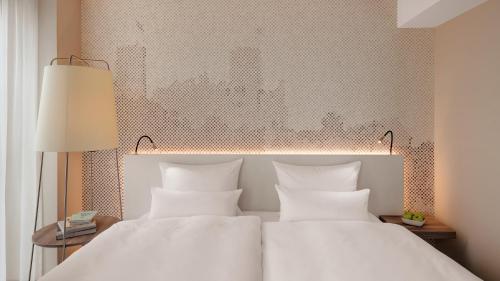 a bedroom with a large bed with white pillows at Hotel Stadt Lörrach in Lörrach