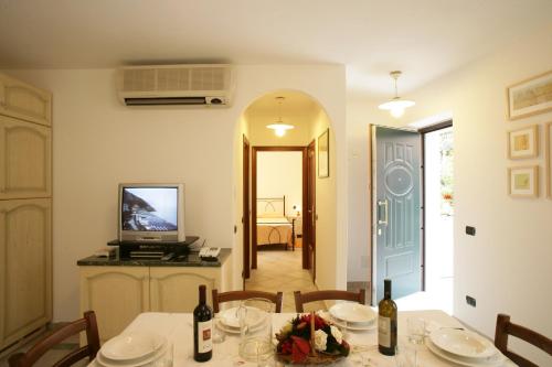a dining room with a table and a television at Appartamenti In Piazzetta in Deiva Marina
