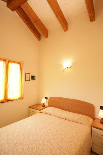 a bedroom with a bed and two night stands and a window at Appartamenti In Piazzetta in Deiva Marina