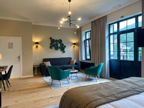 a hotel room with a couch and a table and chairs at Villa Gracia in Namur