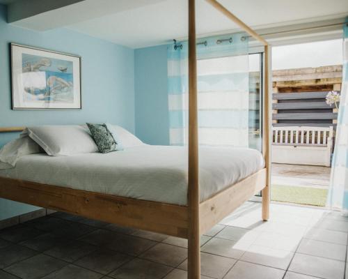sypialnia z łóżkiem z niebieskimi ścianami w obiekcie Villa Balaou - Vue mer exceptionnelle - w mieście Urville-Nacqueville