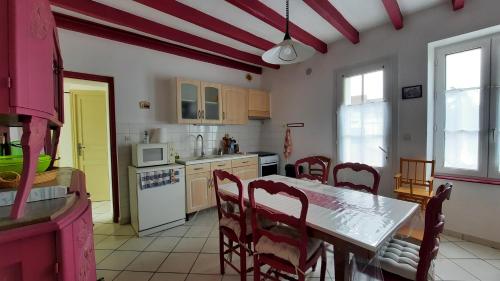 une cuisine avec une table et des chaises dans une pièce dans l'établissement La Gustine, à Descartes
