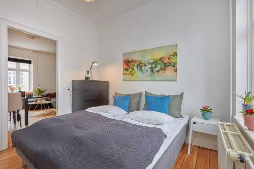 a bedroom with a bed and a painting on the wall at Central Lyngby Apartments in Kongens Lyngby