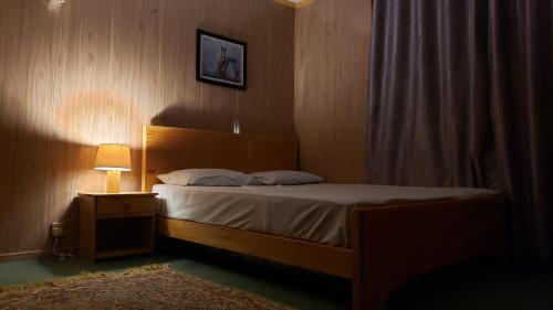 a bedroom with a bed and a night stand with a lamp at Sehrish Guest House Skardu in Skardu