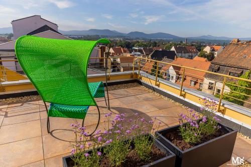 a green chair sitting on top of a balcony at Hotel Sonne in Zittau
