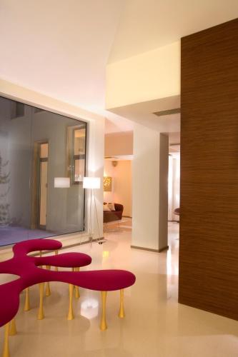 a living room with a table and red chairs at Eos Hotel in Lecce