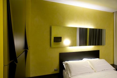 a bedroom with a white bed and a mirror at Eos Hotel in Lecce