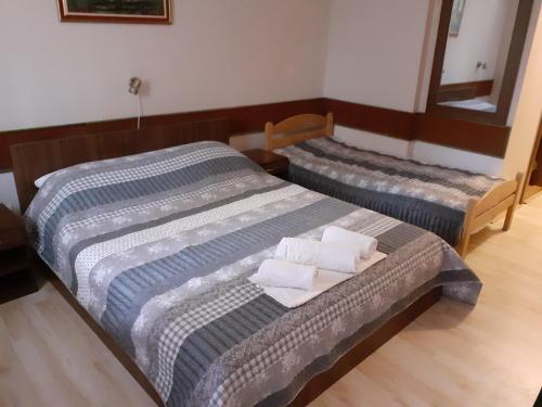 two beds in a room with white towels on them at Restoran sa prenoćištem Žitište in Žitište