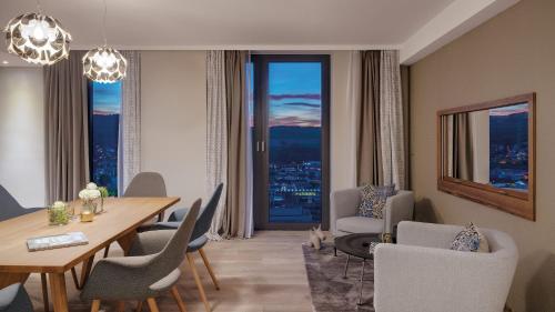 - un salon avec une table et des chaises ainsi qu'une salle à manger dans l'établissement Hotel Stadt Lörrach, à Lörrach