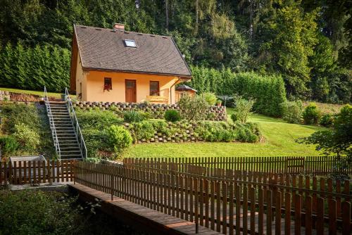 a house with a fence in front of a yard at Rekreační dům Dony in Trutnov