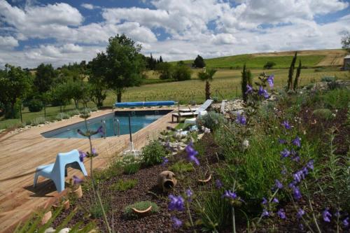 un jardin avec des fleurs violettes et une piscine dans l'établissement Gîte - Holiday Home Vent Tramontane, à Limoux