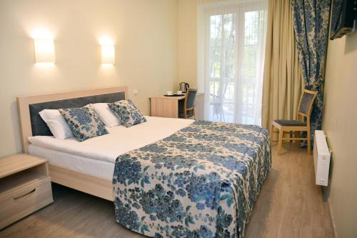 a bedroom with a bed with a blue and white blanket at Sanatorija ,,Tulpės" in Birštonas