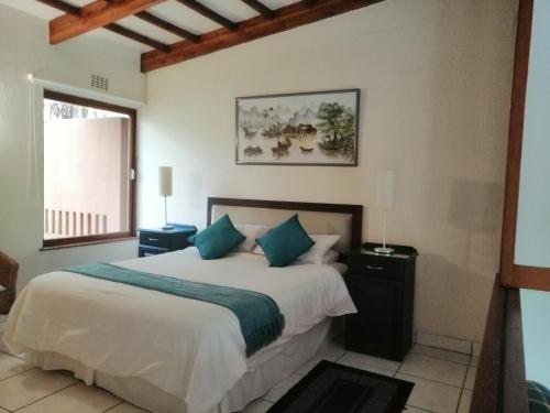 a bedroom with a bed with white sheets and blue pillows at San Lameer Villa 2026 in Southbroom