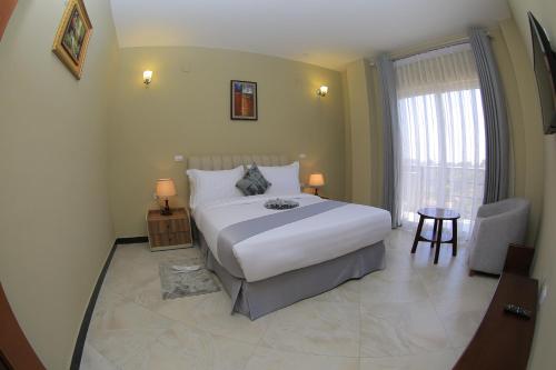 a bedroom with a large white bed and a window at Daisy Hotel in Addis Ababa