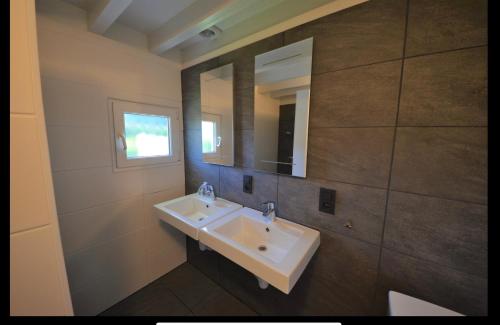 ein Badezimmer mit einem weißen Waschbecken und einem Spiegel in der Unterkunft Kustverhuur, Park Schoneveld, Zeester 25 in Breskens