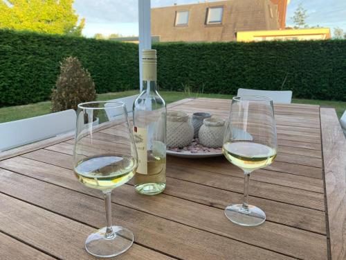 two glasses of white wine sitting on a wooden table at Kustverhuur, Park Schoneveld, Zeester 25 in Breskens