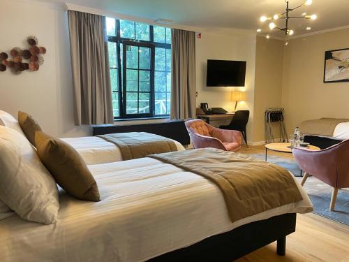 a bedroom with two beds and a living room at Villa Gracia in Namur