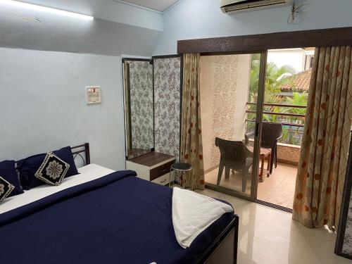 a bedroom with a bed and a balcony with a table at Aroma Villas in Lonavala
