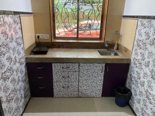 een kleine keuken met een wastafel en een raam bij Aroma Villas in Lonavala