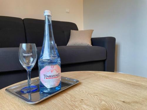 a bottle of water and a glass on a table at Villa Gracia in Namur